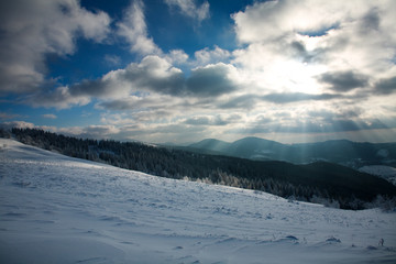 Obraz premium Winter landscape of mountains in rays of the setting sun