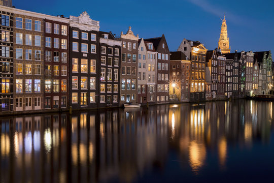 Houses along Damrak canal illuminated at night, Amsterdam, Netherlands