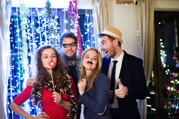 Hipster friends celebrating New Years Eve together, photobooth p - obrazy, fototapety, plakaty