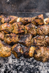 Skewers of lamb cooked on the grill. Wooden background. Top view. Close-up