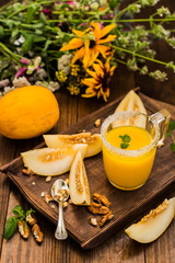 Fresh and ripe melon   juice. Wooden background. Close-up