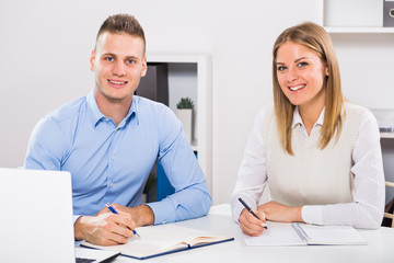 Obraz premium Businesswoman and businessman sitting in office and working together. 