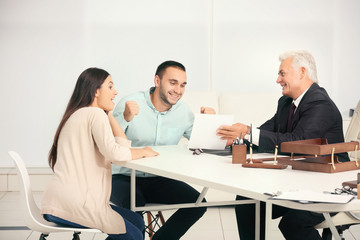 Obraz premium Young couple with notary at office