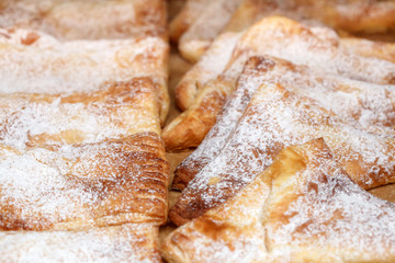 Row of freshly sweet buns with sugar powder, selective focus