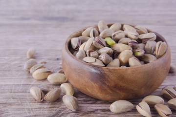 Pistachio nuts scattered on wooden table