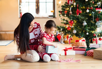 Fototapeta premium Young mother with daugter at Christmas tree at home.