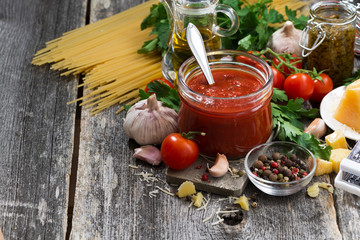 tomato sauce in a glass jar and ingredients 