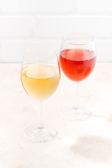 two glasses of wine on white wooden background, vertical