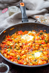 Vertical View of Shakshuka, Traditional Israeli Dish, Scrambled Eggs, Tomatoes, Hot Red Pepper and Herbs, Vertical View