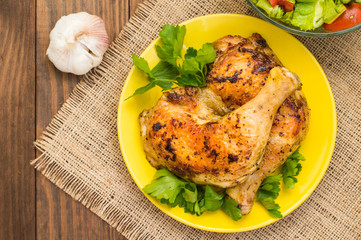 Roasted chicken legs on a wooden background. Top View. Close-up