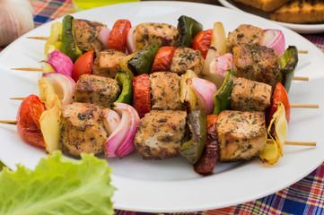 Skewers of chicken and vegetables on wooden . Rural background. Close-up