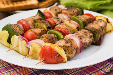 Skewers of chicken and vegetables on wooden . Rural background. Close-up