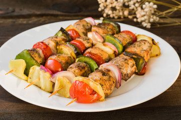 Skewers of chicken and vegetables on wooden . Rural background. Close-up