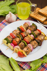 Skewers of chicken and vegetables on wooden . Rural background. Close-up