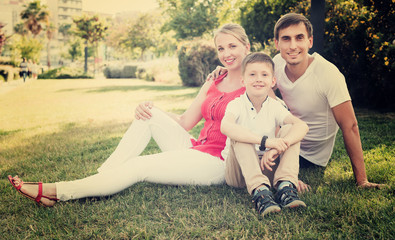 Family sitting on green meadow