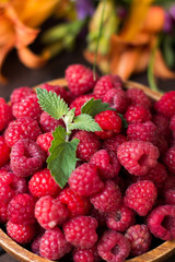 Fresh raspberry in wooden plate. Rural background. Close-up