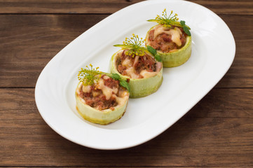 Courgettes stuffed with tomatoes, minced meat, cheese and spices. Wooden background. Top view. Close-up