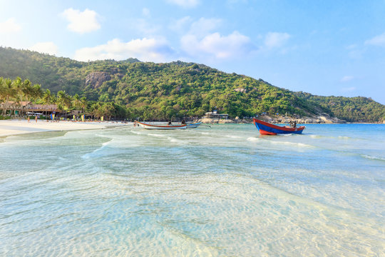 Phangan beach with white sand and traditional long tail boats on cristal clear water