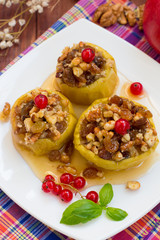 Baked apples with raisins, walnuts and honey for dessert. Wooden rustic background. Close-up. Top view