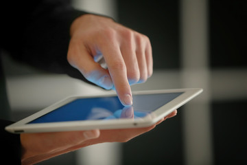 Fototapeta premium Male finger touching tablet screen on blurred background