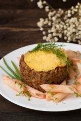 Meat casserole, Italian pasta and cheese crisps. Wooden background. Close-up