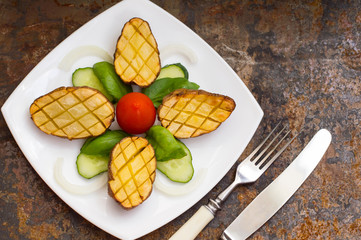 Baked potatoes with vegetables on the background color. Wooden table. Close-up. Top view