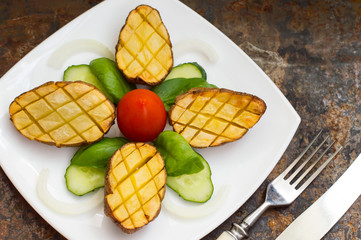 Baked potatoes with vegetables on the background color. Wooden table. Close-up. Top view
