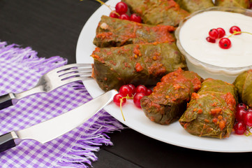 Dolma - this grape leaves stuffed with rice-based, as well boiled minced meat. It is common in kitchens Caucasus, the Balkans, Asia and North Africa.Wooden background. Close-up