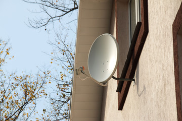 Residential TV receiver satellite dish mounted on a modern cottage