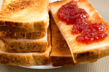 Toasted slices of bread with strawberry jam close-up