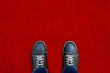 Black shoes standing on red carpet