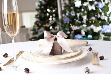 Christmas gifts on the beautiful table with Christmas tree on ba