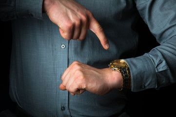Businessman pointing the finger on his gold watch