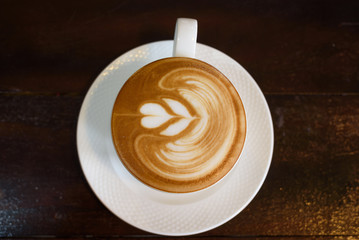 Hot cappuccino on a wooden table in a coffee shop.