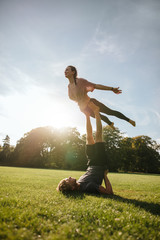 Fototapeta na wymiar Fit young couple doing acrobatic yoga
