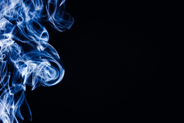 Artistic blue smoke on black background texture.