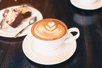 Hot cappuccino on a wooden table in a coffee shop.