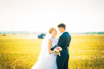 the bride and groom on the background of field