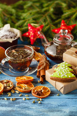 Mulled tea with spices and festive Christmas decorations on wood