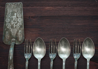 Vintage cutlery on brown wooden surface, top view, an empty spac