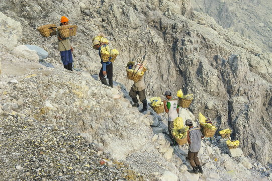 Workers carrying big pieces of sulphur out of the Ijen Volcano, Java, Indonesia