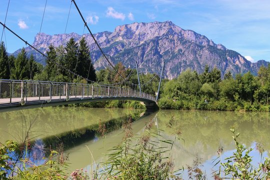 Pedestrian bridge over the Salzach river in Puch, not far from Salzburg city. In the background the mountain Untersberg. Puch, Austria, Europe.