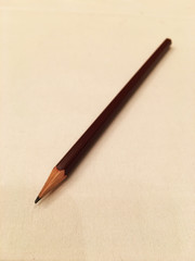 One pencil sticks on a white cloth on the table in the office