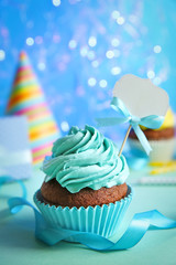 Birthday cupcake with space for text on blurred blue background
