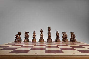 Chessboard with chess pieces. Black set, front wide view angle.