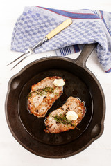 grilled pork chops with thyme in a cast iron pan
