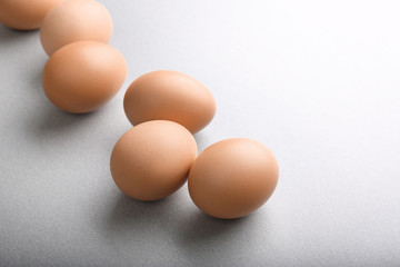 Raw eggs on grey background