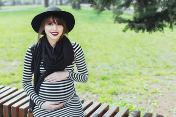 Pregnant girl sitting in park