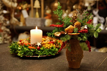 Decorative pine branches in a vase with background Advent wreath with a burning candle
