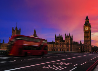 Fototapeta na wymiar London, England, UK. Red buses blured in motion on Westminster bridge with Big Ben, the Palace of Westminster in early morning before sunrise.